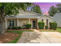 Charming single-story home features a welcoming front porch, manicured landscaping, and a well-maintained lawn at 5402 Harris Cove Dr, Charlotte, NC 28269