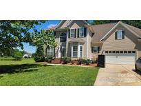 Charming two-story home with a manicured lawn, lush landscaping, and a classic facade at 6504 Sybil Ct, Indian Trail, NC 28079