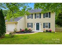 Charming two-story home featuring a well-manicured lawn and attached two-car garage at 8014 Sherington Way, Charlotte, NC 28227