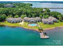 Stunning aerial view of waterfront condos, a community pool, boat docks, and the beautiful Lake Norman at 930 Jetton St, Davidson, NC 28036