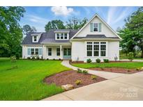 Charming two-story home featuring a manicured lawn, a concrete walkway, and white siding accents at 9311 Simpson Rd, Waxhaw, NC 28173