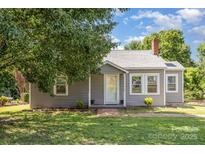 Charming single-story home with gray siding, well-maintained lawn, and inviting front entrance at 1103 Oklahoma St, Kannapolis, NC 28083