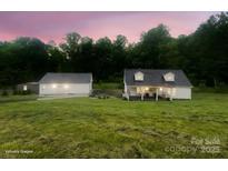 Charming home with detached garage on a lush green lawn and trees in the background at 1135 Brook Path Trl, Denver, NC 28037