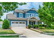 Charming two-story home with a blue exterior, two-car garage, and well-manicured landscaping at 12107 Grey Partridge Dr, Charlotte, NC 28278