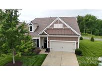 Charming home with a two-car garage, landscaped yard, and a welcoming front entrance at 123 Hanks Bluff Dr, Mooresville, NC 28117