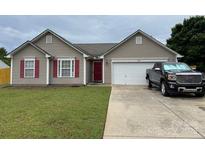 Inviting single-story home with a well-manicured lawn and a convenient two-car garage at 1421 Piney Church Rd, Concord, NC 28025