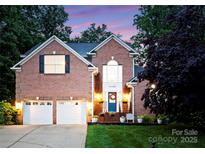 Charming two-story brick home featuring a well-manicured lawn and a welcoming blue front door at 15301 Marsh Field Ct, Huntersville, NC 28078