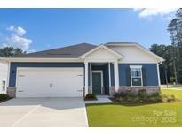 Charming blue single-story home featuring a two-car garage and well-manicured lawn at 1600 Baymont Ct, Stanley, NC 28164