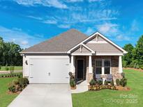 Charming single-story home with stone accents, a two-car garage, manicured lawn, and a welcoming front porch at 1600 Baymont Ct, Stanley, NC 28164
