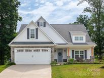Charming single-Gathering home featuring stone accents, a two-car garage, and a well-manicured lawn at 182 Mackenzie Ct, China Grove, NC 28023