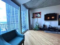 Bright living room with floor to ceiling windows and city views at 210 N Church St, Charlotte, NC 28202