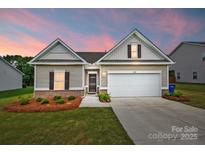 Charming single-Gathering home featuring a two-car garage, manicured lawn, and beautiful landscaping at twilight at 2928 Parkwest Dr, Albemarle, NC 28001