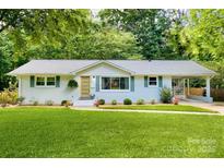 Charming single-story home with a well-manicured lawn, white brick, and a welcoming yellow front door at 3549 Woodleaf Rd, Charlotte, NC 28205