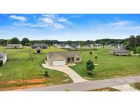 Charming home with a well-manicured lawn in a quiet neighborhood, complemented by a spacious driveway and attached garage at 3645 Kimber Ln, Sherrills Ford, NC 28673