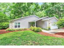 Charming single-story home featuring stone accents and mature landscaping at 3708 Sweetgrass Ln, Charlotte, NC 28226