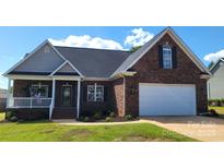 Charming brick home with a two-car garage and well-maintained landscaping in a suburban neighborhood at 3712 Travertine Dr, Lancaster, SC 29720