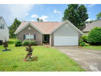 Charming brick home with an attached garage, well-manicured lawn, and inviting landscaping at 4037 Lakota Ct, Charlotte, NC 28269