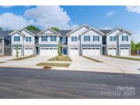New row of townhomes featuring attractive siding, stone accents, private garages and newly planted landscaping at 4041 Port Richmond Ave # 9, Gastonia, NC 28056