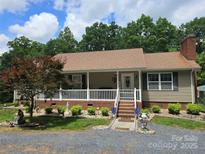 Charming single-story home featuring a welcoming front porch and beautifully landscaped front yard at 490 Deberry Rd, Mount Gilead, NC 27306