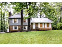 Charming two-story home with brick and siding exterior, surrounded by lush trees and greenery at 509 Selkirk Pl, Charlotte, NC 28270