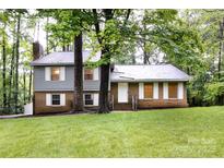 Charming two-story home featuring brick and gray siding, surrounded by lush greenery and mature trees at 509 Selkirk Pl, Charlotte, NC 28270