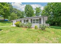 Charming one-story home with a white exterior, black shutters and a well-maintained lawn at 518 Westside Cir, China Grove, NC 28023