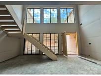 View of the staircase with large windows providing natural light to the open space at 5427 Addison Dr, Charlotte, NC 28211
