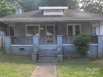 Charming single-story home featuring a covered front porch with blue painted brick and railings at 816 Parkwood Ave, Charlotte, NC 28205