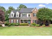 Charming brick two-story home features a lush, landscaped front yard and covered entryway at 9000 Petunia Ct, Gastonia, NC 28056