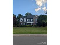 Charming two-story brick home with a well-manicured lawn and mature trees at 9000 Petunia Ct, Gastonia, NC 28056