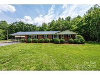 Charming single story home featuring a classic brick exterior and well-manicured lawn and landscape at 1094 Curve View Rd, Lincolnton, NC 28092