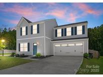 Charming two-story home with light gray siding, dark blue shutters, and a well-manicured lawn at twilight at 110 Browband St, Troutman, NC 28166