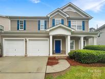 Charming two-story home featuring a welcoming front porch, two-car garage, and blue shutters at 110 Colville Rd, Mooresville, NC 28117