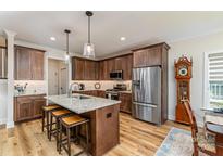 Stylish kitchen features an island with a granite countertop, modern stainless steel appliances, and wooden cabinets at 1109 Bunch Dr, Statesville, NC 28677