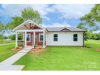 Charming single-story home with a covered front porch, well-manicured lawn and sidewalk to the front door at 1244 Bob Falls Rd, Shelby, NC 28150