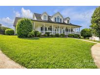 Charming two-story home with a welcoming, spacious front porch and lush green lawn at 129 Renaissance Pl, Statesville, NC 28625