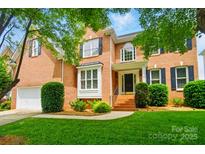 Charming brick two-story home with manicured lawn, black shutters, and inviting front entrance at 138 Montibello Dr, Mooresville, NC 28117