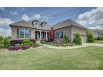 Charming brick home featuring a well-manicured lawn and beautiful landscaping at 14503 Crest Ct, Charlotte, NC 28278
