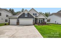 Charming home featuring a three-car garage, well-manicured lawn and inviting curb appeal at 1528 Croydon St, Indian Land, SC 29707