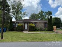 Charming stone home featuring mature landscaping, a well-manicured lawn, and a welcoming entrance at 157 5Th N Ave, Taylorsville, NC 28681