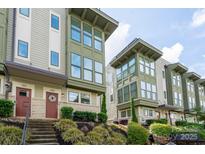 Inviting townhouse exterior with multi-level facade, front yard landscaping, and steps to a welcoming red door at 1707 Cannon View Ln, Charlotte, NC 28208