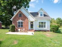 Charming brick and vinyl home featuring a manicured lawn and inviting front porch at 1918 Gables Dr, Monroe, NC 28112