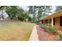 Brick home featuring mature landscaping, a sidewalk and a glimpse of a charming, tree-lined yard at 2001 Lakeview Dr, Pineville, NC 28134