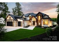 Stunning modern home featuring a beautiful blend of wood and stone accents and a well manicured lawn at 301 Riverwood Rd, Mooresville, NC 28117