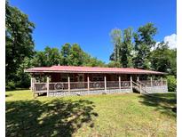 Charming single-story home with a red roof, inviting front porch, and lush green lawn at 3988 Old Hickory Rd, Lancaster, SC 29720