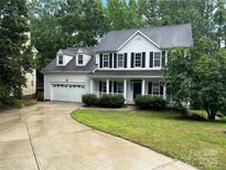 Charming two-story home boasts a two-car garage, dark shutters, and a welcoming front porch at 4504 Bellmore Ct, Charlotte, NC 28269