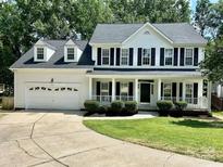 Charming two-story white home with a welcoming front porch, black shutters, and well-manicured lawn at 4504 Bellmore Ct, Charlotte, NC 28269