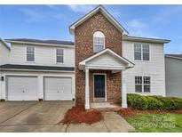 Charming two-story home featuring a brick facade, attached two-car garage, and inviting front porch at 752 Raindrops Rd, Gastonia, NC 28054