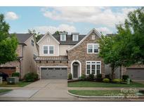 Charming stone and siding two-story home with a two-car garage and well-manicured lawn at 7913 Waverly Walk Ave, Charlotte, NC 28277