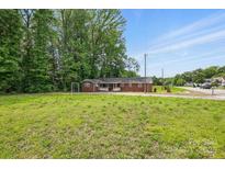 Single story brick home with a large front lawn and mature trees offering lots of privacy at 800 Old Little Rock Rd, Charlotte, NC 28214
